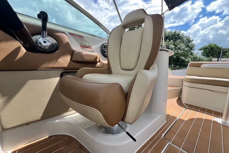 Slide: The Image of 2007 Sea Ray 260 Sundeck interior with beige captain's chair and wooden deck. - 36