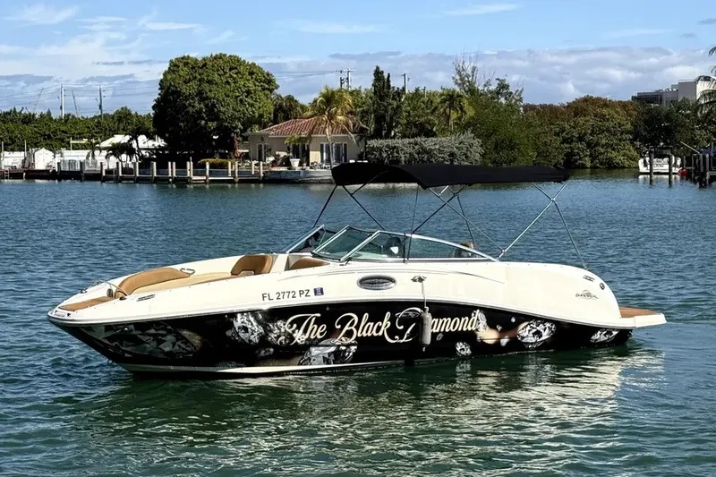 Slide: The Image of 2007 Sea Ray 260 Sundeck boat named "The Black Diamond" on a serene waterway. - 1