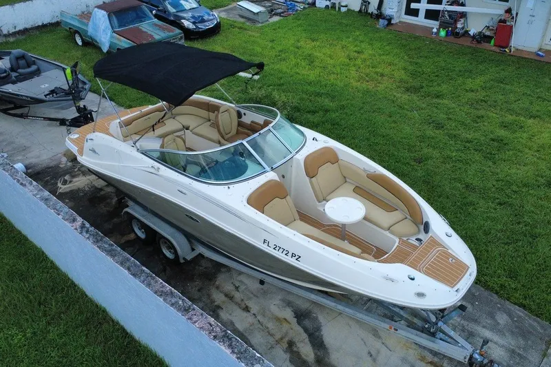 The Image of 2007 Sea Ray 260 Sundeck boat on trailer, parked in a grassy yard. - 0