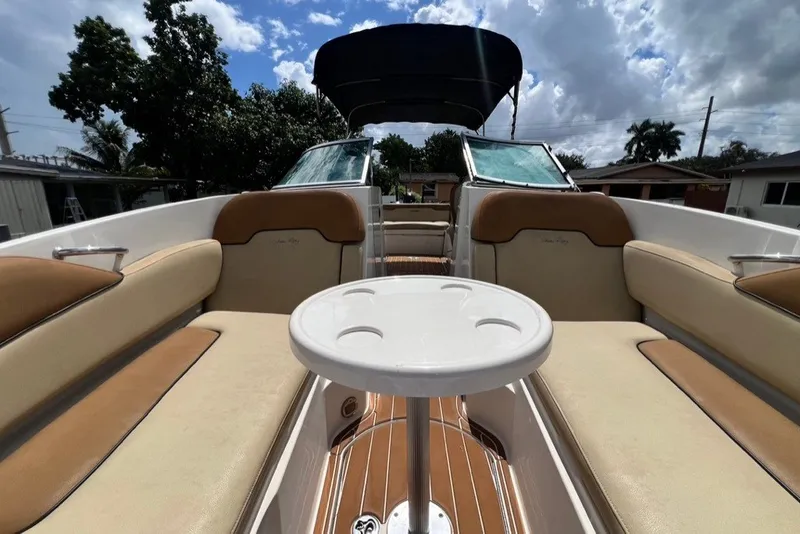 Slide: The Image of 2007 Sea Ray 260 Sundeck interior with tan seating and round table under a blue sky. - 21