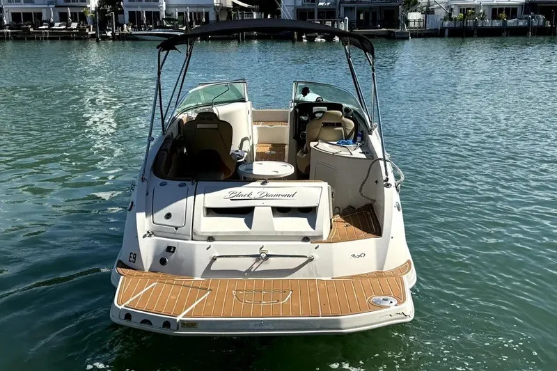 Slide: The Image of 2007 Sea Ray 260 Sundeck boat on water, rear view with teak deck and canopy. - 6