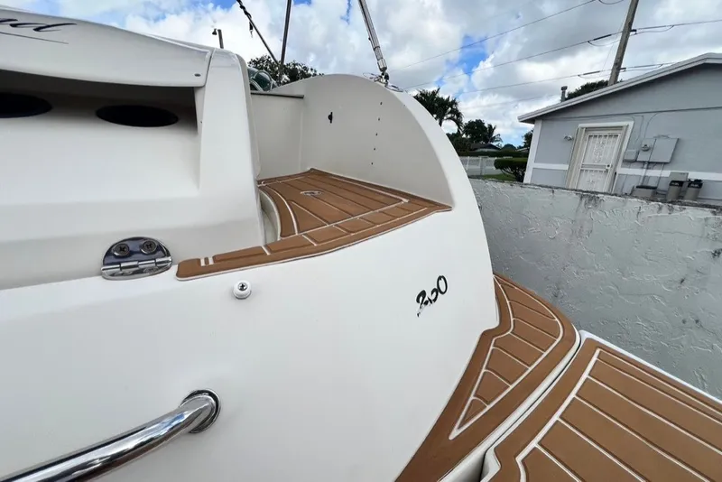 Slide: The Image of 2007 Sea Ray 260 Sundeck boat with teak-style decking, docked near a residential area. - 77