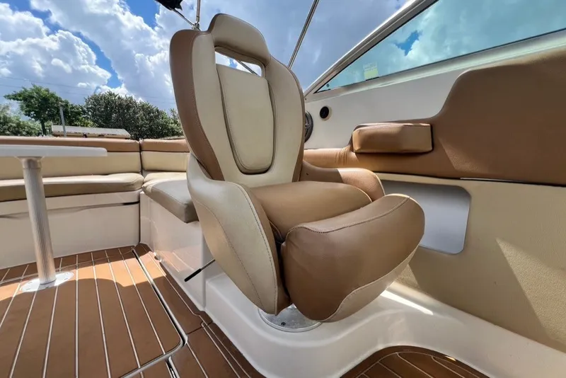 Slide: The Image of 2007 Sea Ray 260 Sundeck interior with tan seating and wood flooring under a blue sky. - 35