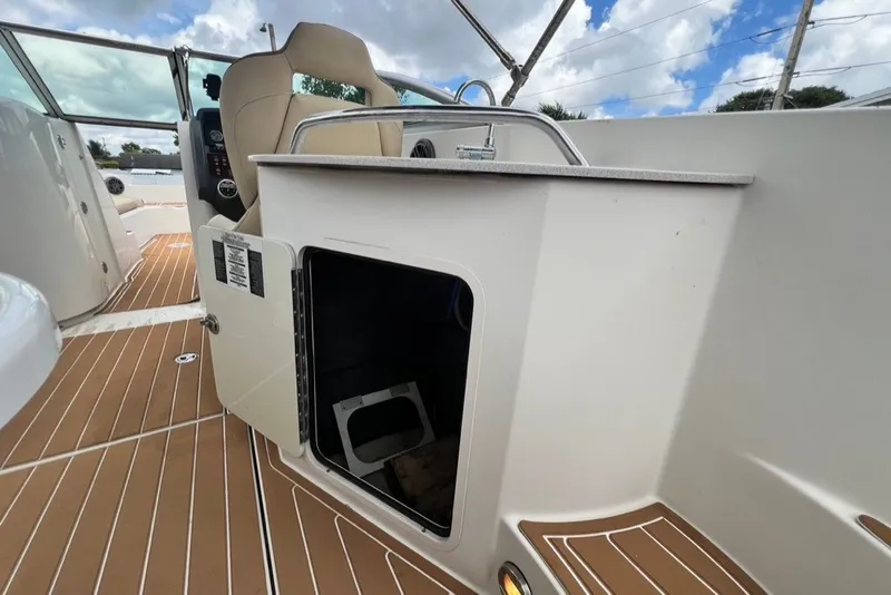 Slide: The Image of 2007 Sea Ray 260 Sundeck interior with open storage compartment and beige seating. - 70