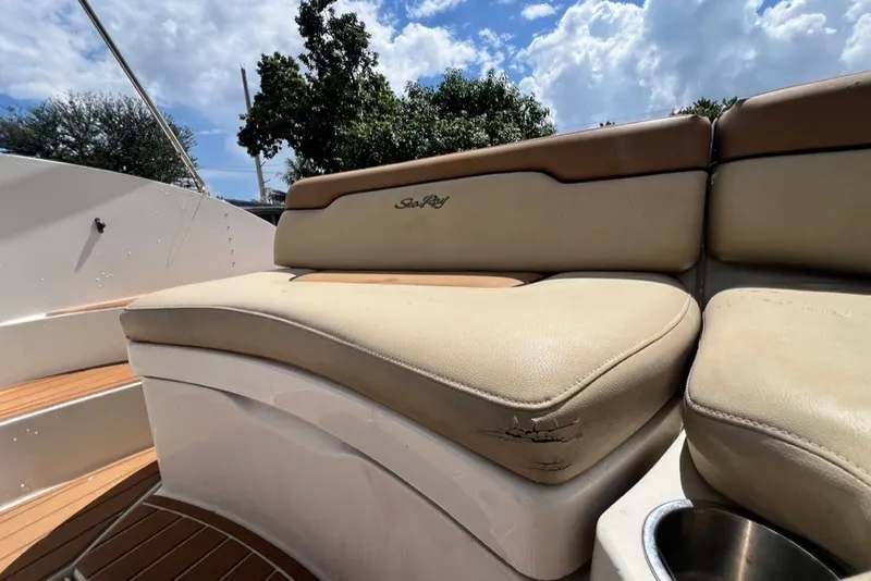 Slide: The Image of 2007 Sea Ray 260 Sundeck boat seating with beige upholstery under a sunny sky. - 18