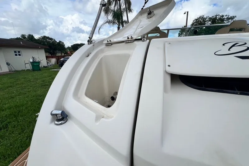 Slide: The Image of Open storage compartment on a 2007 Sea Ray 260 Sundeck boat, with lush greenery background. - 78