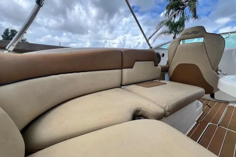 Slide: The Image of 2007 Sea Ray 260 Sundeck interior with beige and brown seating under cloudy sky. - 72