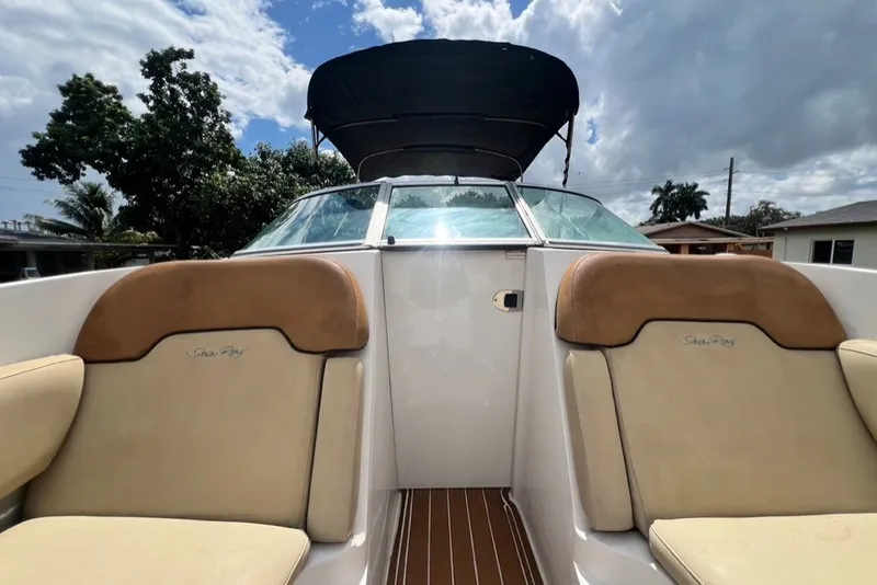 Slide: The Image of 2007 Sea Ray 260 Sundeck boat interior with tan seating and canopy under cloudy sky. - 40