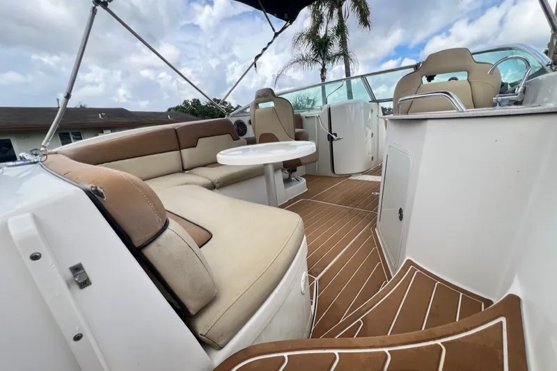 Slide: The Image of 2007 Sea Ray 260 Sundeck interior with beige seating, table, and wood-patterned flooring. - 76