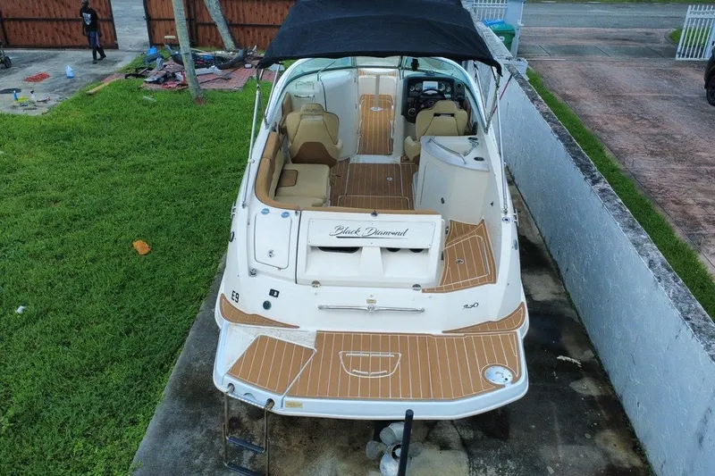 Slide: The Image of 2007 Sea Ray 260 Sundeck boat with canopy, docked on grass, rear view. - 11