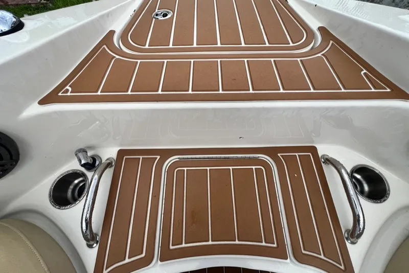 Slide: The Image of 2007 Sea Ray 260 Sundeck boat deck with brown non-slip surface and stainless steel handles. - 50