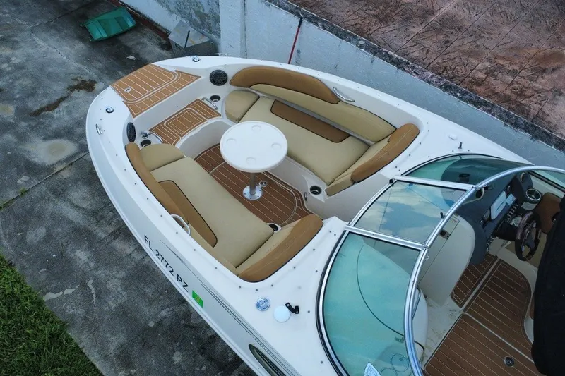Slide: The Image of 2007 Sea Ray 260 Sundeck boat with tan seating and a round table, docked on concrete. - 4