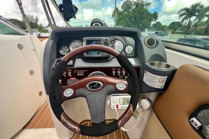 Slide: The Image of 2007 Sea Ray 260 Sundeck dashboard with steering wheel and control panel. - 87