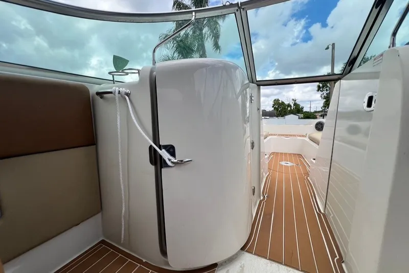 Slide: The Image of 2007 Sea Ray 260 Sundeck interior with teak flooring and enclosed cabin under a blue sky. - 63