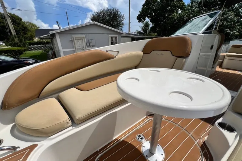 Slide: The Image of 2007 Sea Ray 260 Sundeck interior with cushioned seating and round table. - 23