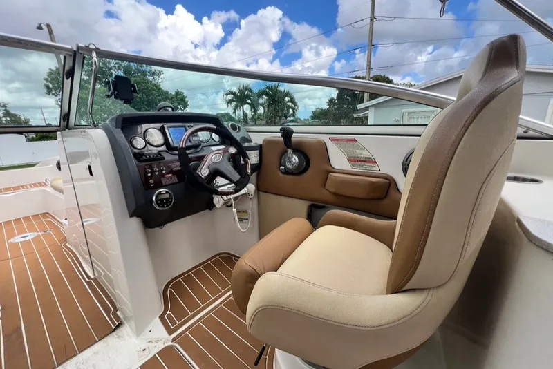 Slide: The Image of 2007 Sea Ray 260 Sundeck helm with steering wheel and control panel, featuring tan seating. - 62