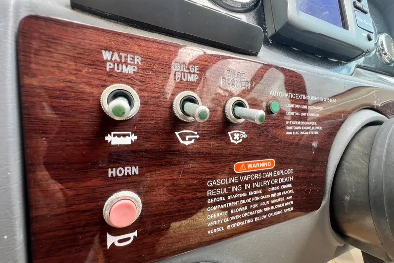 Slide: The Image of Control panel of a 2007 Sea Ray 260 Sundeck with switches and safety warnings. - 60