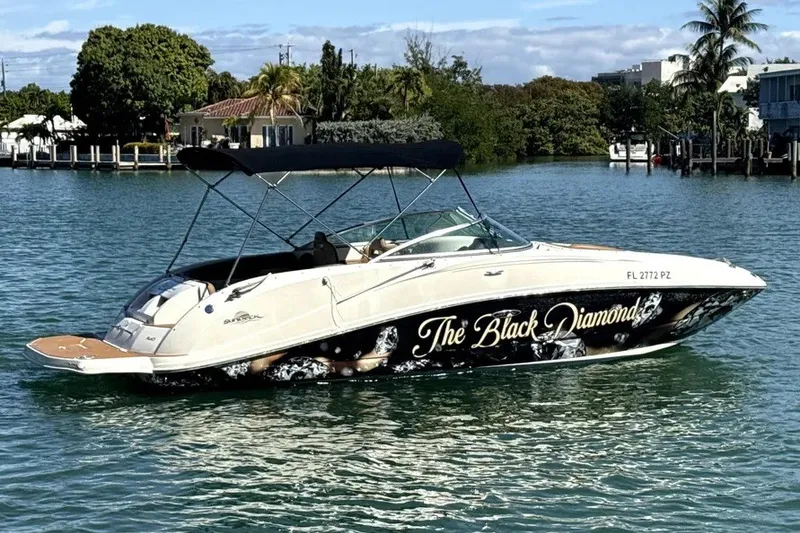 Slide: The Image of 2007 Sea Ray 260 Sundeck boat named "The Black Diamond" on calm water. - 2