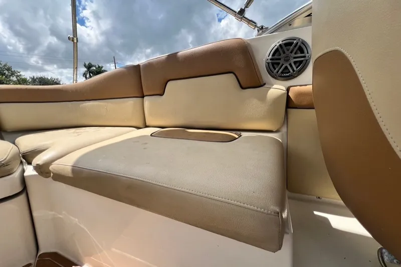 Slide: The Image of 2007 Sea Ray 260 Sundeck interior with beige and brown seating under cloudy sky. - 29