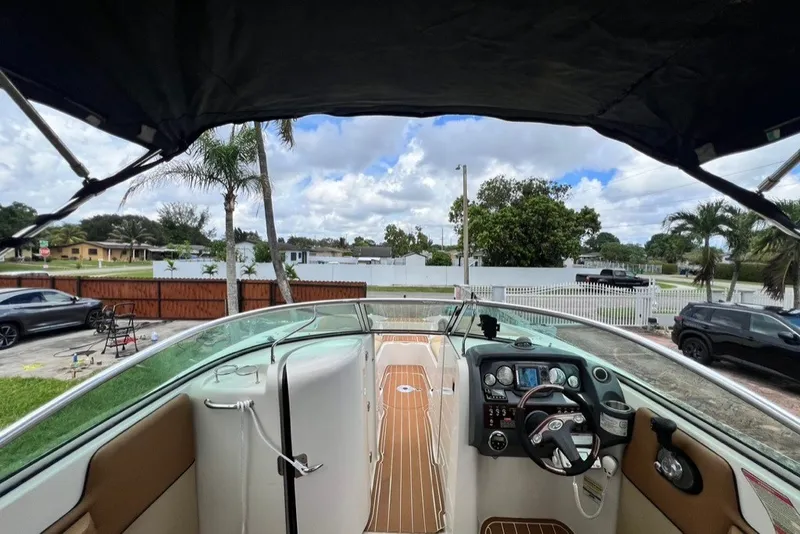 Slide: The Image of 2007 Sea Ray 260 Sundeck boat interior with steering wheel and dashboard, parked outdoors. - 68