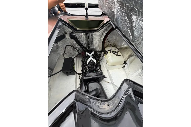 Slide: The Image of Das Bild zeigt den Motorraum eines Wassersportfahrzeugs mit freiliegenden Kabeln und Komponenten. - 16