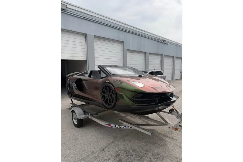 The Image of Un JetCar de Watersports Car de 2026 está en un remolque frente a garajes. - 1