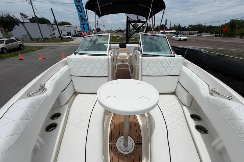Slide: The Image of 2007 Sea Ray SLX 250 boat interior with white seating and table, parked outdoors. - 46
