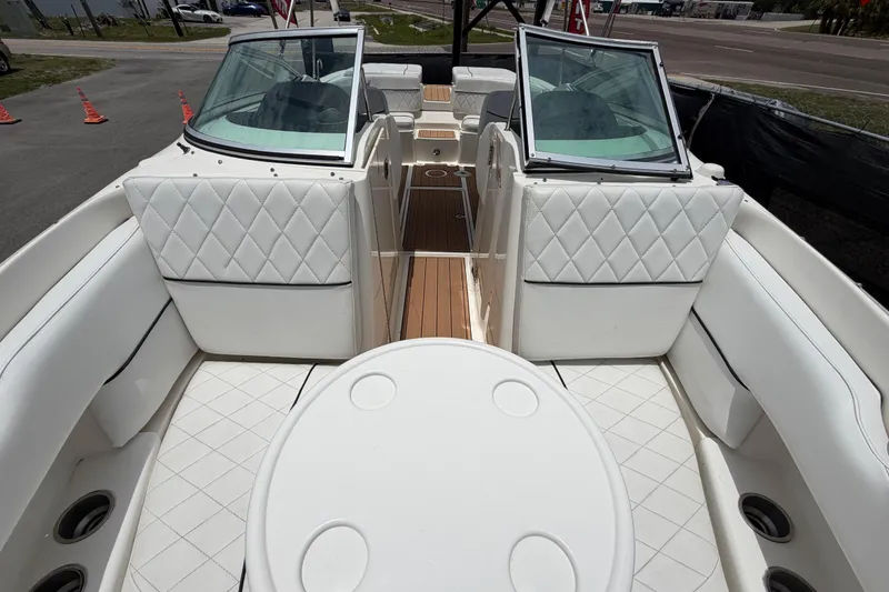 Slide: The Image of Interior view of a 2007 Sea Ray SLX 250 boat with white seating and wood flooring. - 53