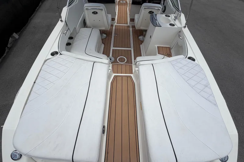 Slide: The Image of 2007 Sea Ray SLX 250 boat interior with white seating and wooden flooring. - 18