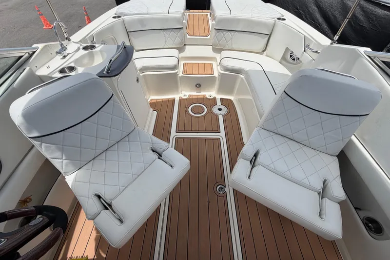 Slide: The Image of Interior of a 2007 Sea Ray SLX 250 boat with white seating and wood flooring. - 56