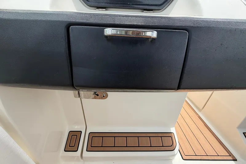 Slide: The Image of 2007 Sea Ray SLX 250 boat dashboard with storage compartment and teak flooring. - 61