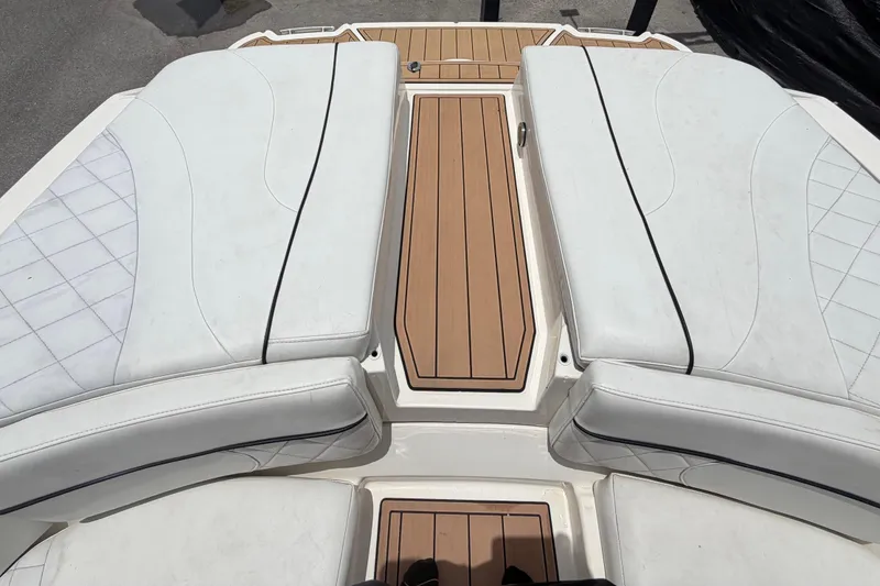 Slide: The Image of 2007 Sea Ray SLX 250 boat with white cushioned seating and teak deck. - 77