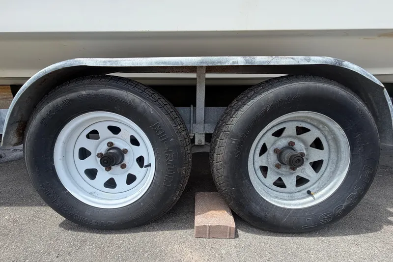 Slide: The Image of Trailer wheels of a 2007 Sea Ray SLX 250 boat on pavement. - 83