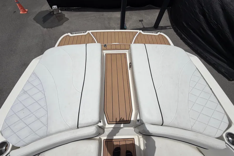 Slide: The Image of 2007 Sea Ray SLX 250 boat deck with white cushioned seating and teak flooring. - 76