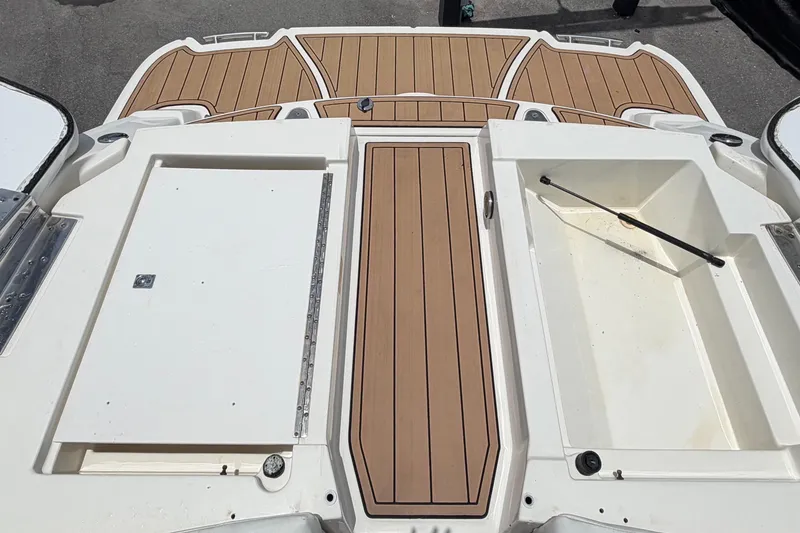 Slide: The Image of 2007 Sea Ray SLX 250 boat deck with storage compartments and wood-like flooring. - 79