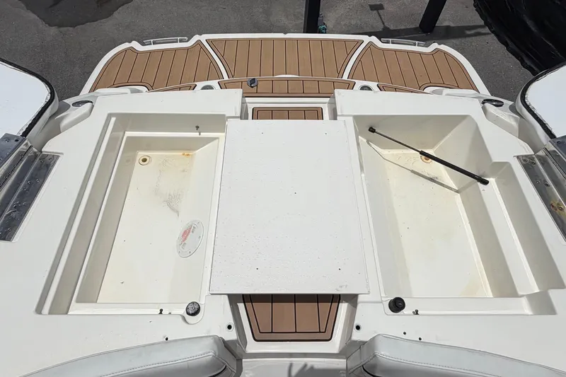 Slide: The Image of 2007 Sea Ray SLX 250 boat deck with storage compartments and teak flooring. - 78