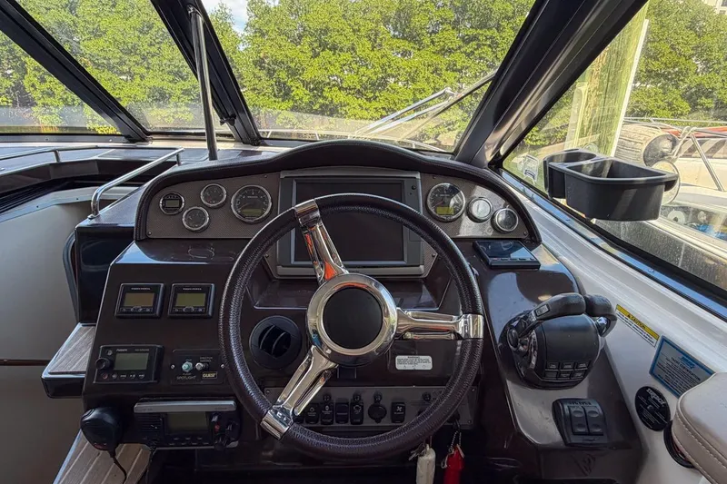 Slide: The Image of 2015 Regal 38 Express boat helm with steering wheel and control panel. - 53