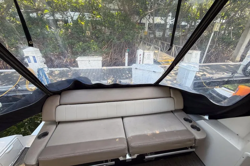 Slide: The Image of 2015 Regal 38 Express boat interior with cushioned seating and marina view. - 50