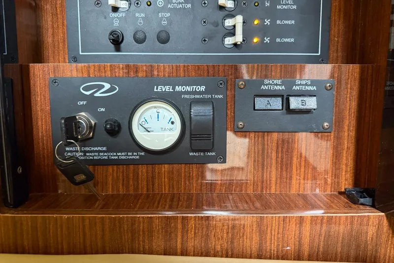 Slide: The Image of Control panel of a 2015 Regal 38 Express boat with level monitor and antenna switches. - 122
