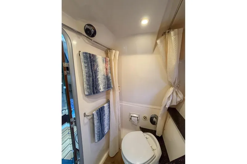 Slide: The Image of Bathroom interior of 2015 Regal 38 Express yacht with towels and toilet. - 93