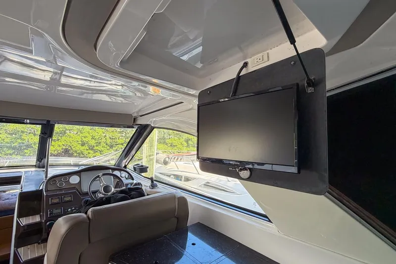 Slide: The Image of Interior of 2015 Regal 38 Express yacht with steering wheel and mounted TV. - 71