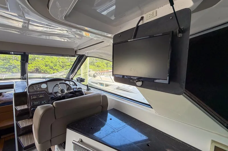 Slide: The Image of Interior of 2015 Regal 38 Express yacht with steering wheel and mounted TV. - 74