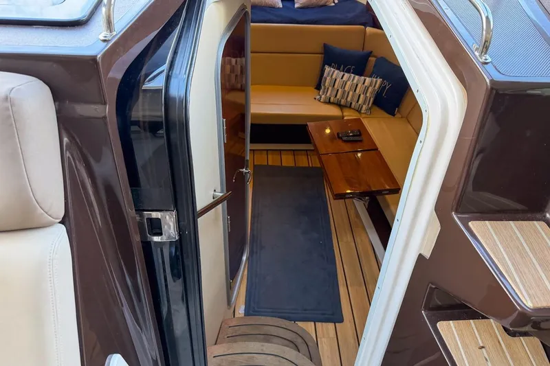 Slide: The Image of Interior view of 2015 Regal 38 Express yacht with cozy seating and wooden table. - 64