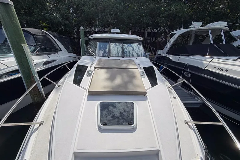 Slide: The Image of 2015 Regal 38 Express yacht docked among other boats, showcasing sleek design and spacious deck. - 35