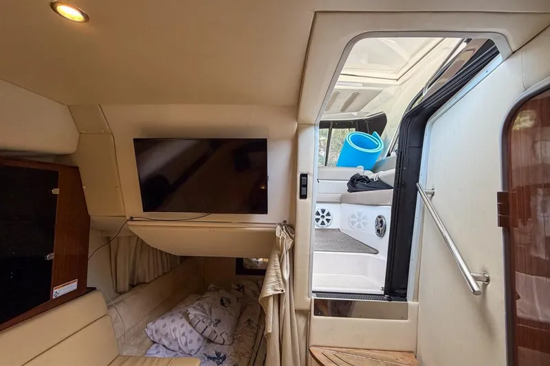 Slide: The Image of 2015 Regal 38 Express yacht interior with TV, seating, and stairs to deck. - 111