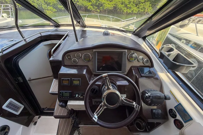 Slide: The Image of Cockpit of 2015 Regal 38 Express boat with steering wheel and control panel. - 55