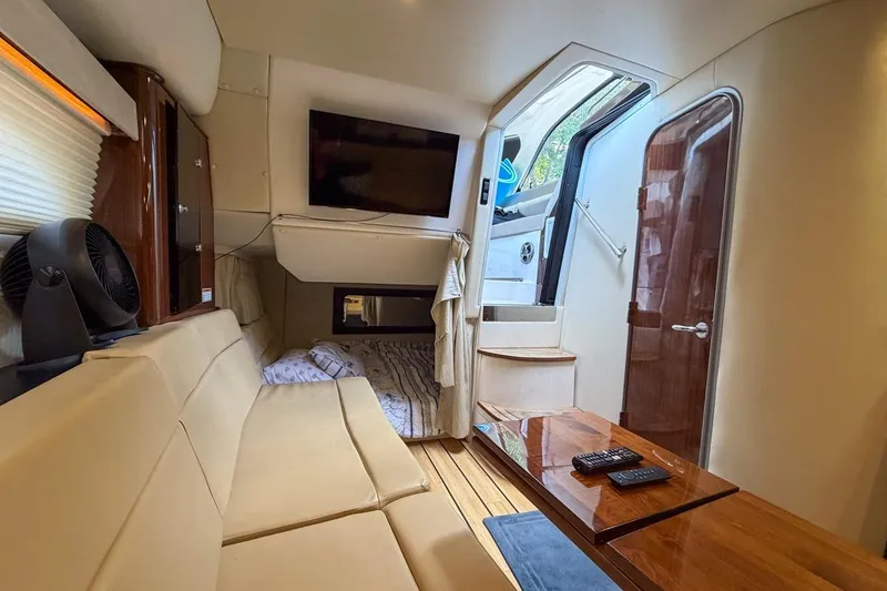 Slide: The Image of Interior of 2015 Regal 38 Express yacht with cozy seating, TV, and wooden accents. - 112