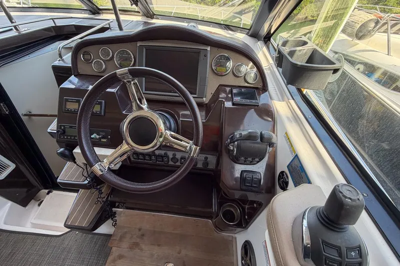 Slide: The Image of 2015 Regal 38 Express boat helm with steering wheel and control panel. - 54