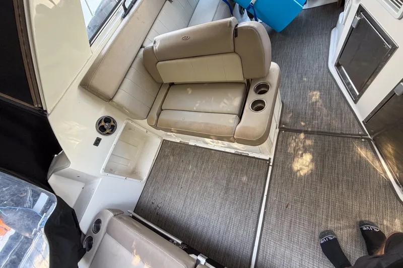 Slide: The Image of Interior of a 2015 Regal 38 Express boat with beige seating and carpeted floor. - 76