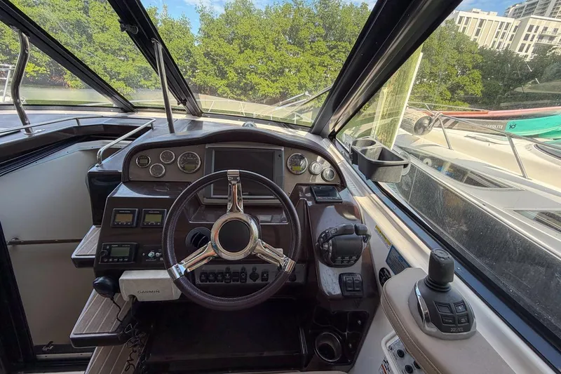 Slide: The Image of 2015 Regal 38 Express boat helm with steering wheel and control panel. - 52